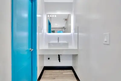 a bathroom with a sink and a blue door at Royal Hawaiian Inn - Mid City, Los Angeles in Los Angeles