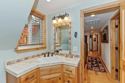 a bathroom with a sink and a mirror at Lakefront Estate w Private Dock HotTub FirePit Lagunita Shores by AvantStay in Big Bear Lake