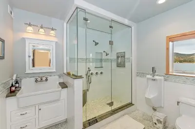 a white bathroom with a shower and a sink at Lakefront Estate w Private Dock HotTub FirePit Lagunita Shores by AvantStay in Big Bear Lake