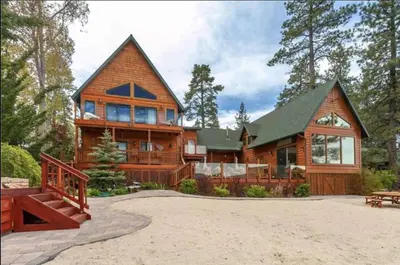 a large wooden house with a gambrel at Lakefront Estate w Private Dock HotTub FirePit Lagunita Shores by AvantStay in Big Bear Lake