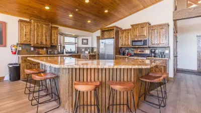 a kitchen with a large island with bar stools at Lakefront Lodge by AvantStay Direct Access to Big Bear Lake Hot Tub Views in Big Bear Lake