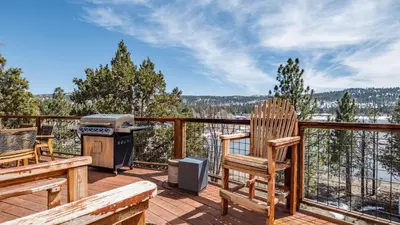 a deck with a grill and two chairs and a barbecue at Lakefront Lodge by AvantStay Direct Access to Big Bear Lake Hot Tub Views in Big Bear Lake