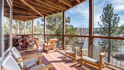 a screened in porch with chairs and a table at Lakefront Lodge by AvantStay Direct Access to Big Bear Lake Hot Tub Views in Big Bear Lake