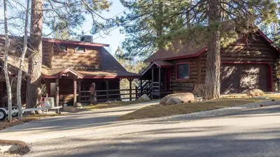 a log cabin with a car parked in front of it at Shoreline Lakehouse by AvantStay Majestic Lakefront Cabin w Hot Tub Fire Pit in Big Bear Lake
