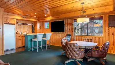 a kitchen and dining room with a table and chairs at Shoreline Lakehouse by AvantStay Majestic Lakefront Cabin w Hot Tub Fire Pit in Big Bear Lake