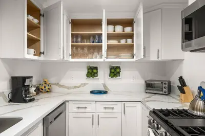a white kitchen with white cabinets and appliances at The Avalon - 35 Percent Off March! in Los Angeles