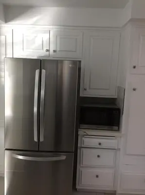 a stainless steel refrigerator in a kitchen with white cabinets at Modern spacious home close to Universal studio & Hollywood for 11 in Los Angeles