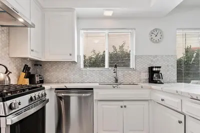 a kitchen with white cabinets and a sink and a stove at Modern spacious home close to Universal studio & Hollywood for 11 in Los Angeles
