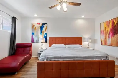 a bedroom with a bed and a red couch at Modern spacious home close to Universal studio & Hollywood for 11 in Los Angeles