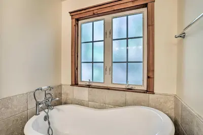 a bath tub in a bathroom with a window at Spacious Lake Arrowhead Home with Putting Green in Lake Arrowhead