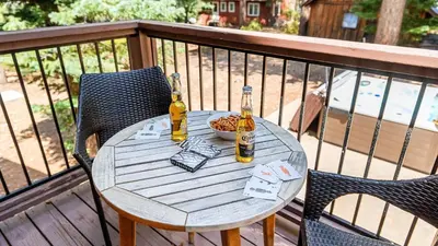 two bottles of beer sitting on a table on a deck at Teddy by AvantStay Majestic Cabin in Big Bear w Balcony in Big Bear Lake