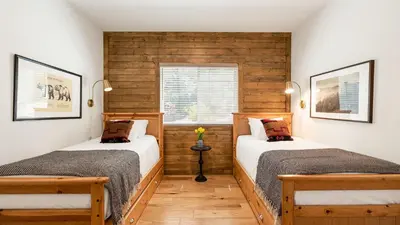 two beds in a room with wooden walls at Teddy by AvantStay Majestic Cabin in Big Bear w Balcony in Big Bear Lake