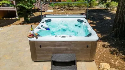 a jacuzzi tub sitting on a patio at Teddy by AvantStay Majestic Cabin in Big Bear w Balcony in Big Bear Lake