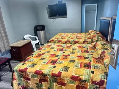a bedroom with a bed with a colorful quilt at King Castle Motel in Los Angeles