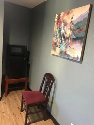 a room with a chair and a painting on the wall at King Castle Motel in Los Angeles