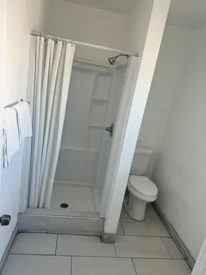 a bathroom with a shower and a toilet at King Castle Motel in Los Angeles