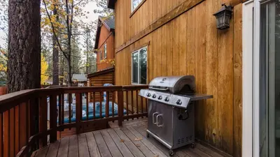 a grill on a wooden deck next to a house at Jackhorn by AvantStay Close to Big Bear Marina and Village Hot Tub Foosball in Big Bear Lake