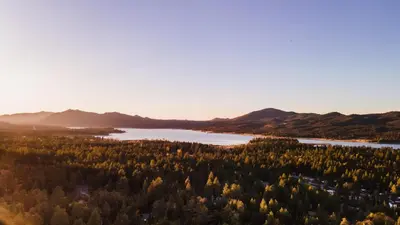 an aerial view of a lake with trees and mountains at Jackhorn by AvantStay Close to Big Bear Marina and Village Hot Tub Foosball in Big Bear Lake