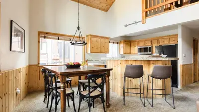 a kitchen with a wooden table and chairs at Jackhorn by AvantStay Close to Big Bear Marina and Village Hot Tub Foosball in Big Bear Lake