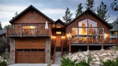 a log house with a deck and a garage at Bernard by AvantStay Luxurious Cabin in Big Bear w Hot Tub Pool Table in Big Bear Lake