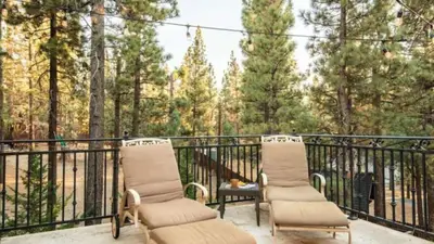 two chairs sitting on a balcony with trees at Big Bear Castle by AvantStay Private Home in Great Big Bear Location w Hot Tub in Big Bear Lake