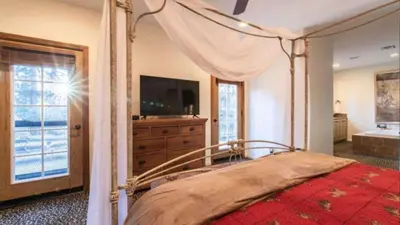 a bedroom with a canopy bed and a television at Big Bear Castle by AvantStay Private Home in Great Big Bear Location w Hot Tub in Big Bear Lake