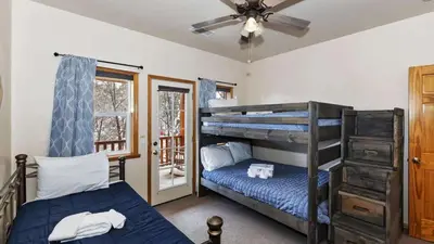 a bedroom with two bunk beds and a ceiling fan at Zen Den by AvantStay Entertainers Home in Ideal Big Bear Location w Hot Tub in Big Bear Lake