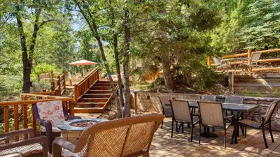 a patio with a table and chairs and stairs at Zen Den by AvantStay Entertainers Home in Ideal Big Bear Location w Hot Tub in Big Bear Lake