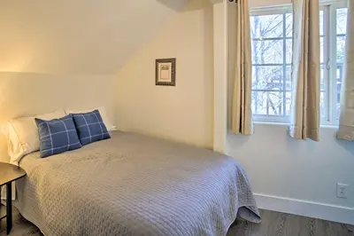 a bedroom with a bed with blue pillows and a window at Relaxing Lake Arrowhead Home about 1 Mi to Lake! in Lake Arrowhead