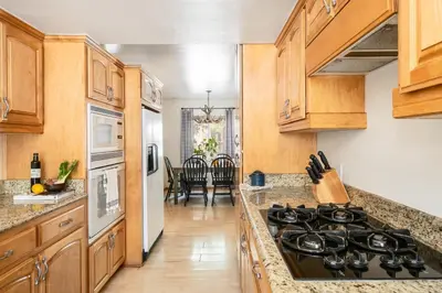 a kitchen with wooden cabinets and a stove top oven at Hartwood by AvantStay Cozy Big Bear Abode w Spacious Deck Stone Fireplace in Big Bear Lake