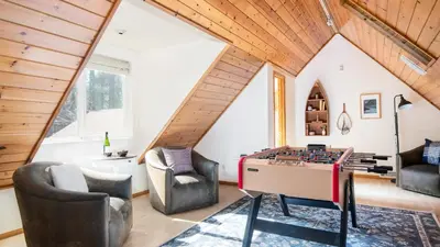 a room with a foosball table and two chairs at Hartwood by AvantStay Cozy Big Bear Abode w Spacious Deck Stone Fireplace in Big Bear Lake