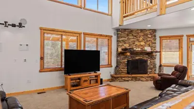 a living room with a television and a fireplace at Starlight Retreat by AvantStay Gorgeous Log Style Home w Incredible Views in Big Bear Lake