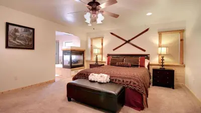 a bedroom with a large bed and a ceiling fan at Starlight Retreat by AvantStay Gorgeous Log Style Home w Incredible Views in Big Bear Lake