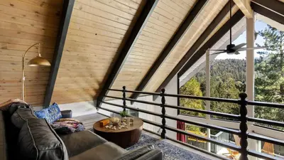 a living room with a couch and a large window at Hot Tub Fire Pit Deck Views Near the Lake The Matterhorn Manor by AvantStay in Crestline