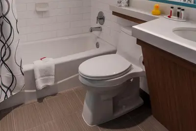 a bathroom with a white toilet and a sink at Howard Johnson by Wyndham Anaheim Hotel and Water Playground in Anaheim