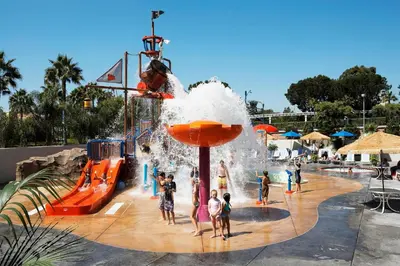 a group of children playing in a water park at Howard Johnson by Wyndham Anaheim Hotel and Water Playground in Anaheim