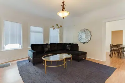 a living room with a black couch and a table at 5 Bedroom Koreatown Charmer near DTLA in Los Angeles