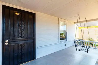 a porch with a black door and a swing at 5 Bedroom Koreatown Charmer near DTLA in Los Angeles