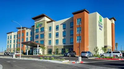 a large building with cars parked in a parking lot at Holiday Inn Express & Suites Ridgecrest - China Lake by IHG in Ridgecrest