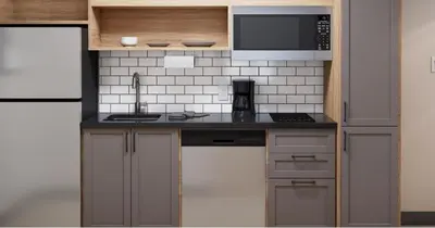 a small kitchen with a sink and a microwave at Candlewood Suites - Loma Linda - San Bernardino S by IHG in Loma Linda