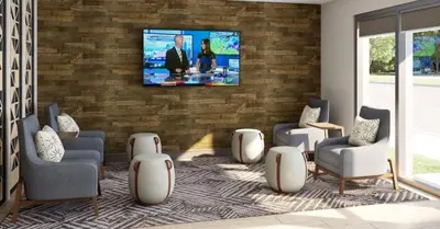 a living room with a tv on a brick wall at Candlewood Suites - Loma Linda - San Bernardino S by IHG in Loma Linda