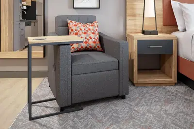 a chair and a desk in a room with a bed at Candlewood Suites - Loma Linda - San Bernardino S by IHG in Loma Linda