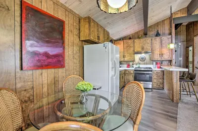 a kitchen with a glass table and a refrigerator at Lake Arrowhead Cabin with Mid-Century Charm! in Lake Arrowhead