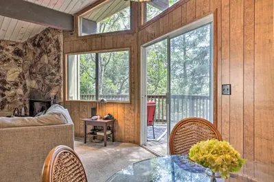 a living room with a glass table and chairs at Lake Arrowhead Cabin with Mid-Century Charm! in Lake Arrowhead