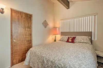 a bedroom with a bed and a wooden door at Lake Arrowhead Cabin with Mid-Century Charm! in Lake Arrowhead