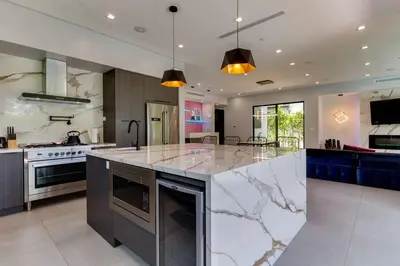 a large kitchen with a large marble counter top at Posh Luxury Modern Home with Pool Spa and Rooftop Deck in Encino