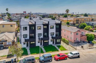 an apartment building with cars parked in a parking lot at Luxury Modern 4 bedroom 3 Bath Home With Rooftop Deck #3 in Los Angeles