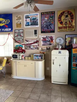 a room with a refrigerator and posters on the wall at My Oasis in Bakersfield