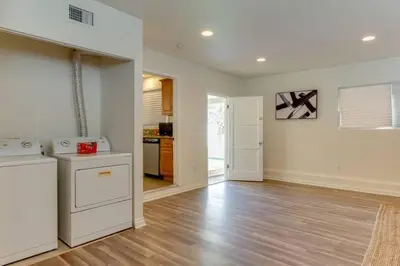 a kitchen with white appliances and a wooden floor at 5 Bedroom Charmer in Granada Hills in Granada Hills