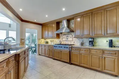 a large kitchen with wooden cabinets and a stove at Beverly Hills City View Mansion in Los Angeles
